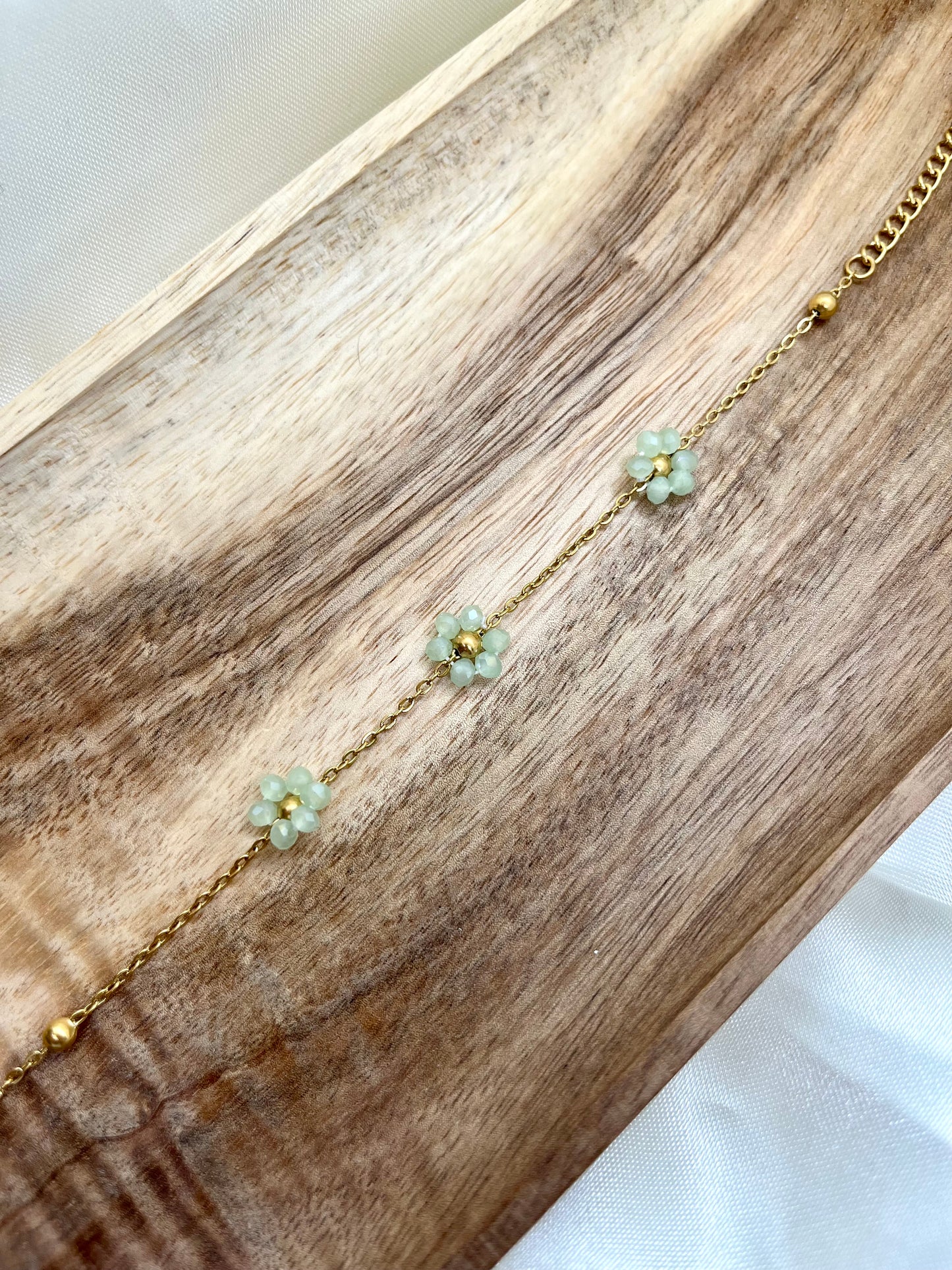 Bracelet doré et fleurs vert d’eau