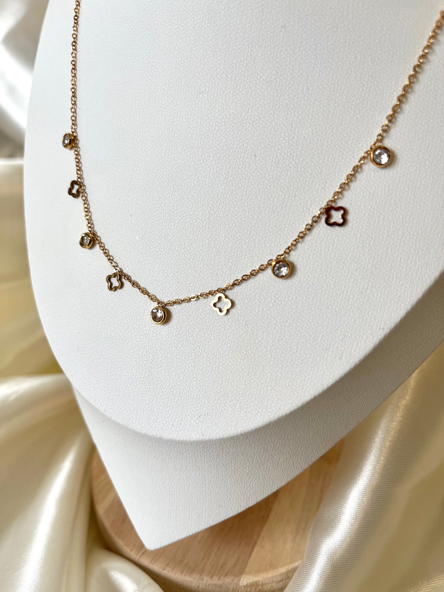 Collier doré pendentifs strass et trèfles