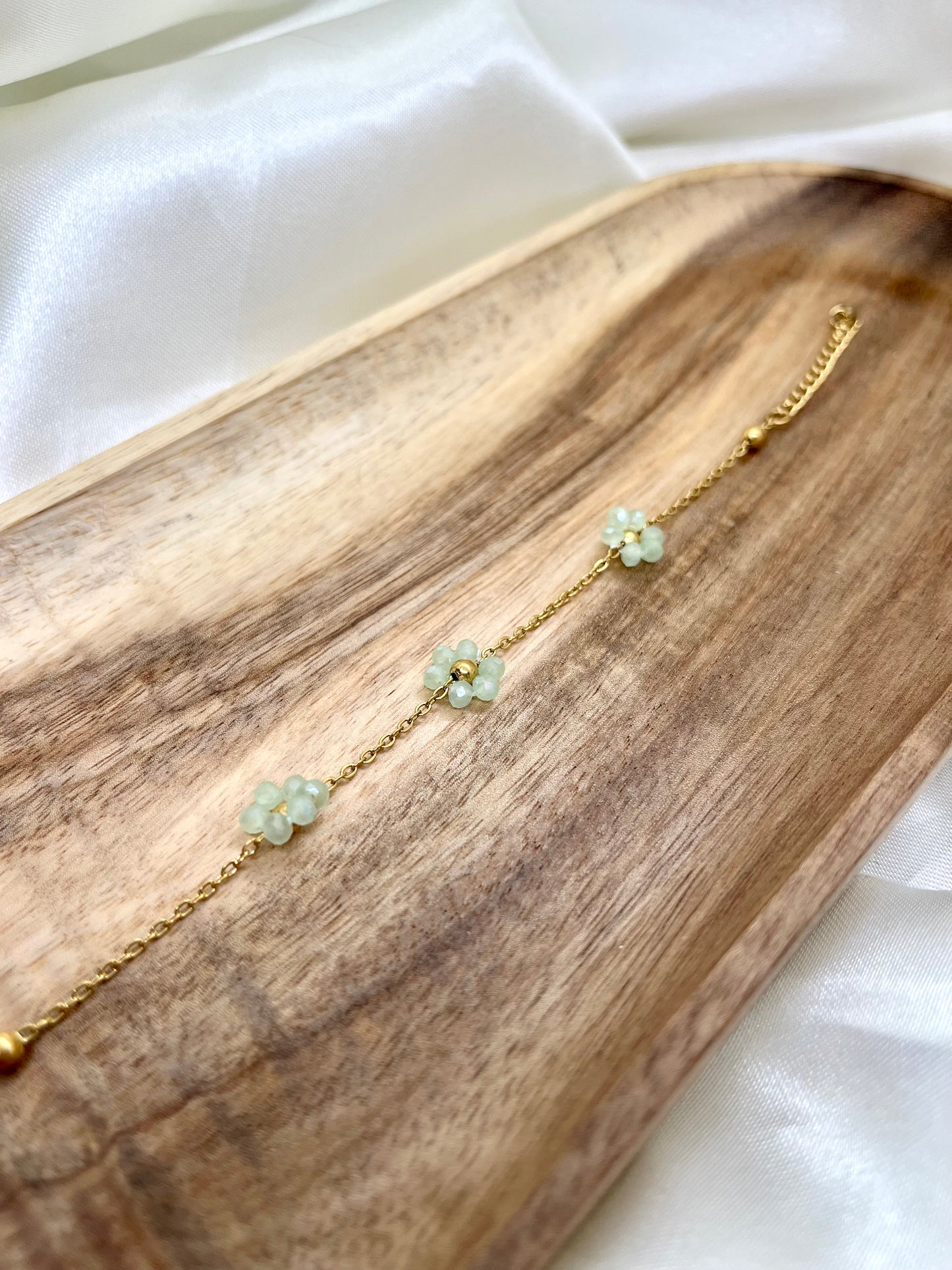 Bracelet doré et fleurs vert d’eau